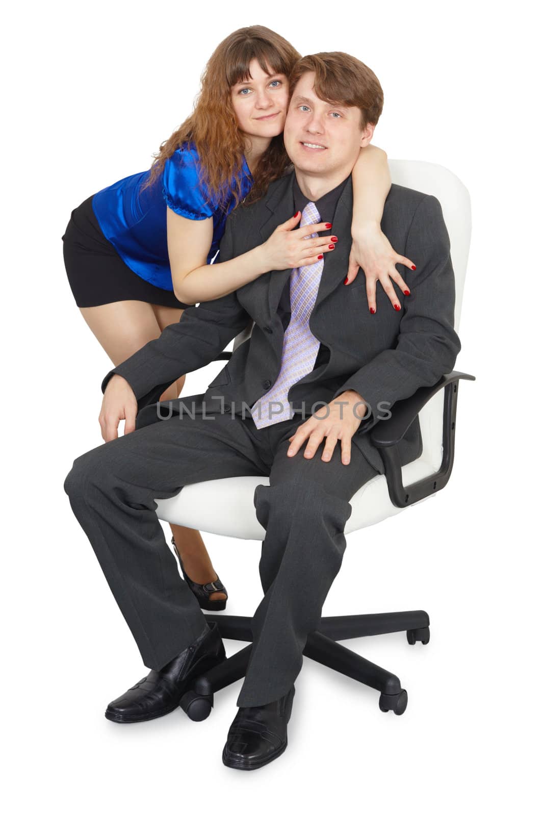 A woman embraces a young man sitting in an office chair