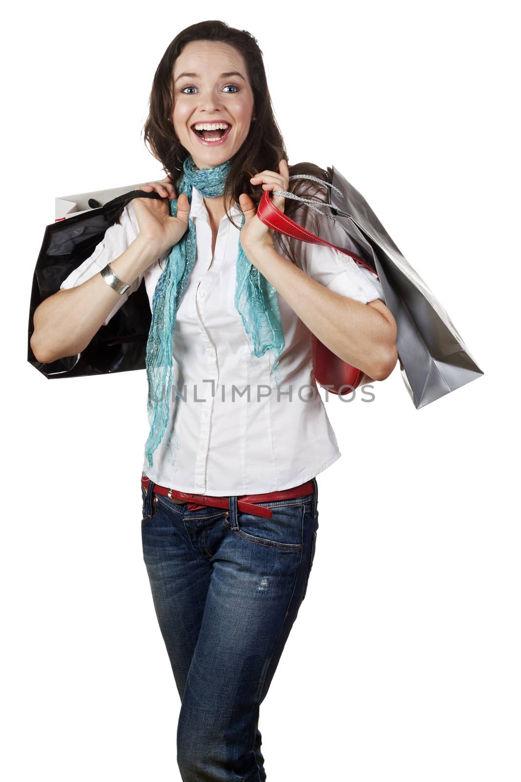 A very beautiful, casual and happy girl holding shopping bags and laughing. Isolated on white.