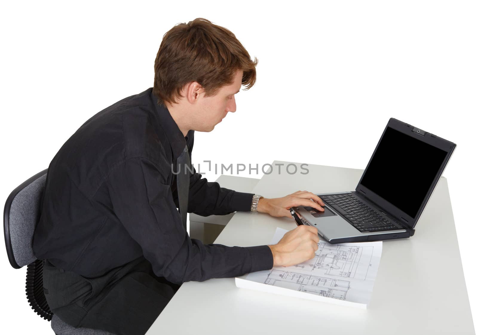 The young man is working while sitting at desk