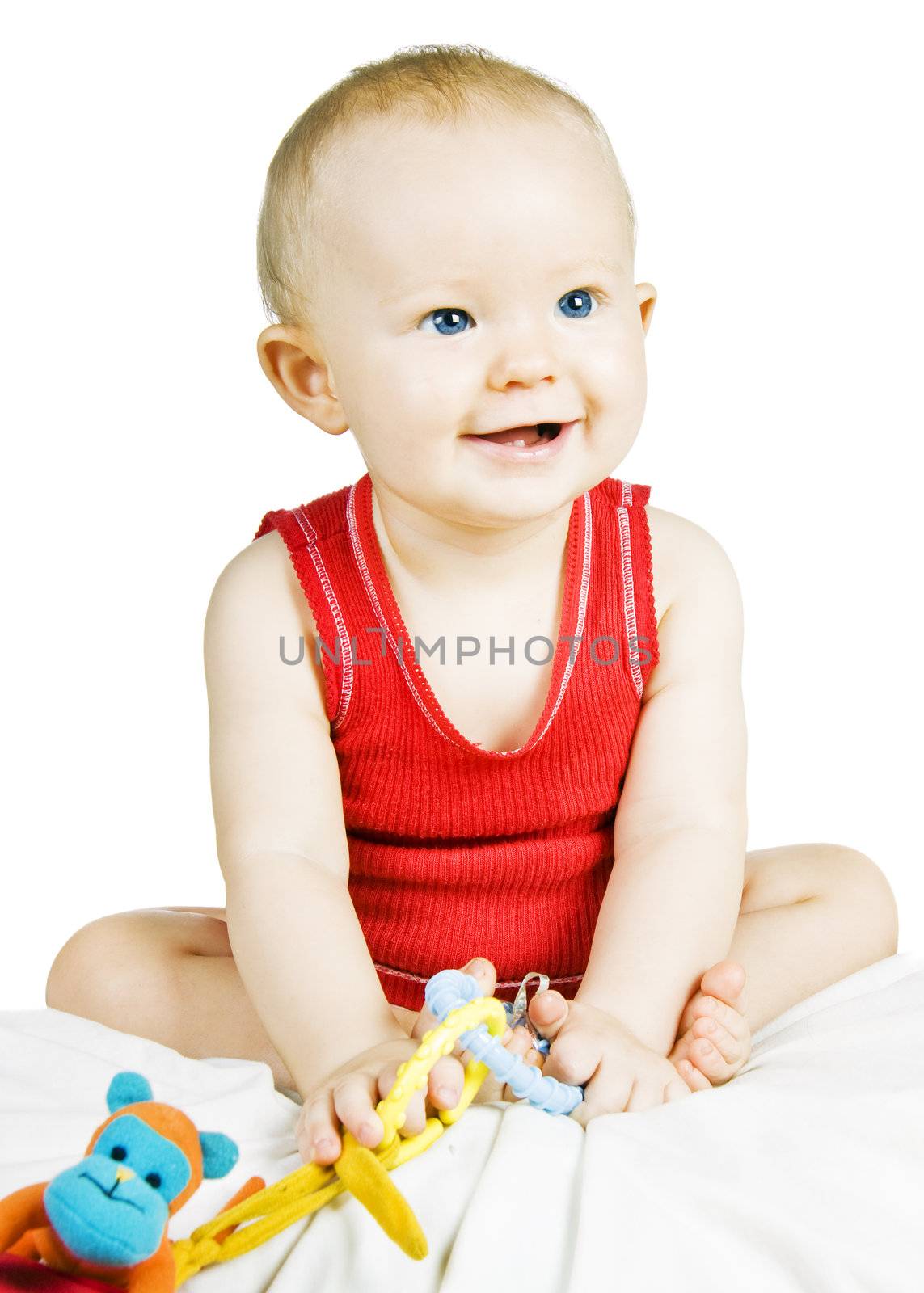 A gorgeous blond baby boy with blue eyes sitting up smiling 