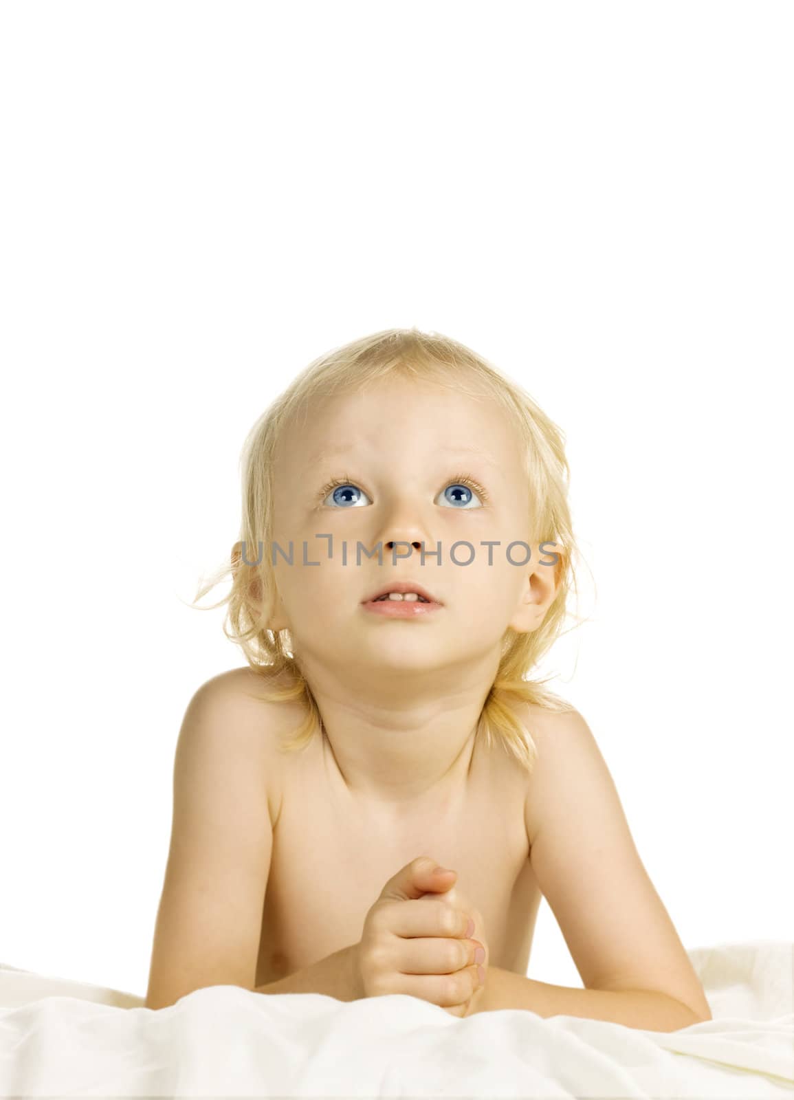 A cute young blond boy looking up and praying. Isolated over white.