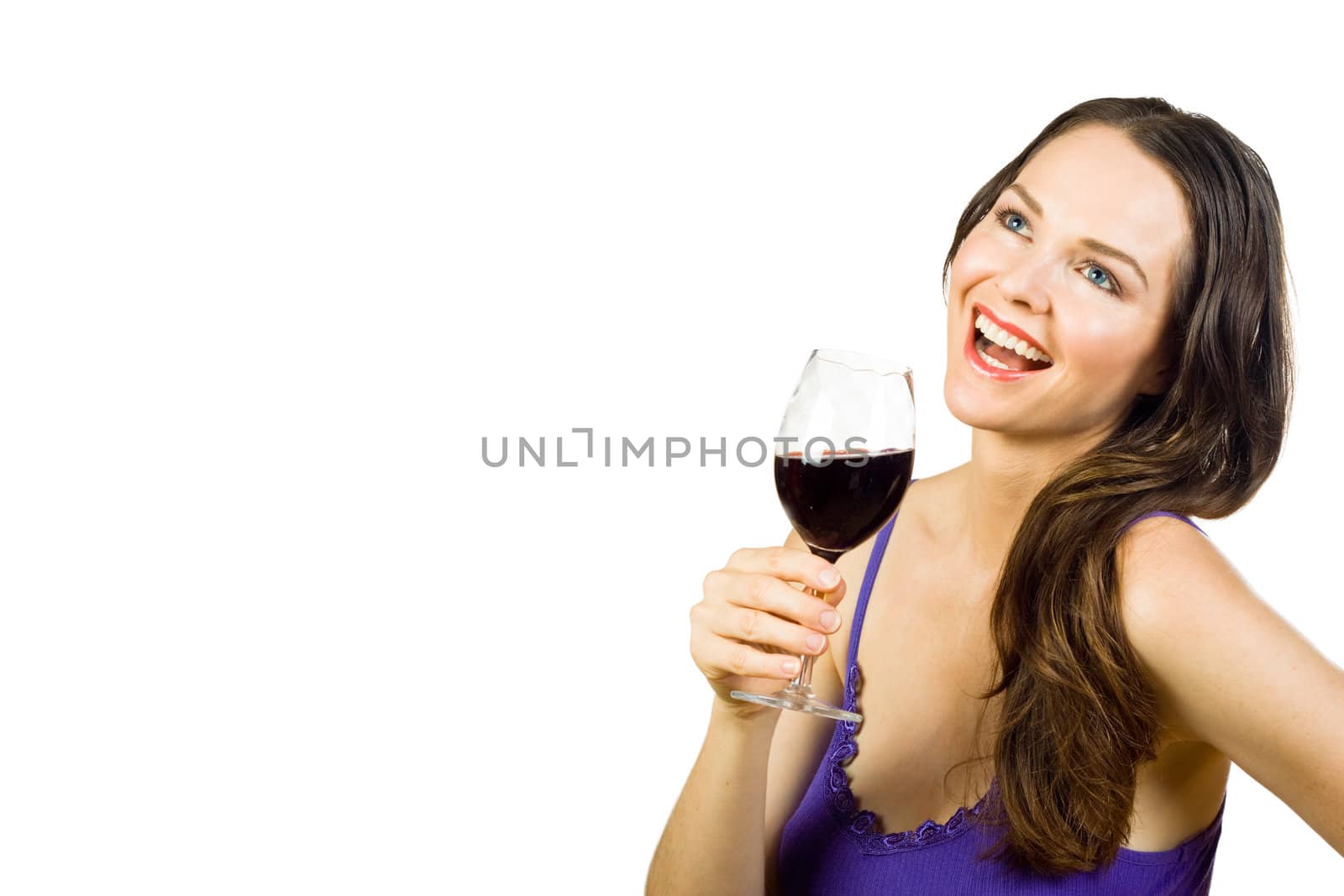 Beautiful young brunette laughing and holding a glass of red wine. Isolated over white