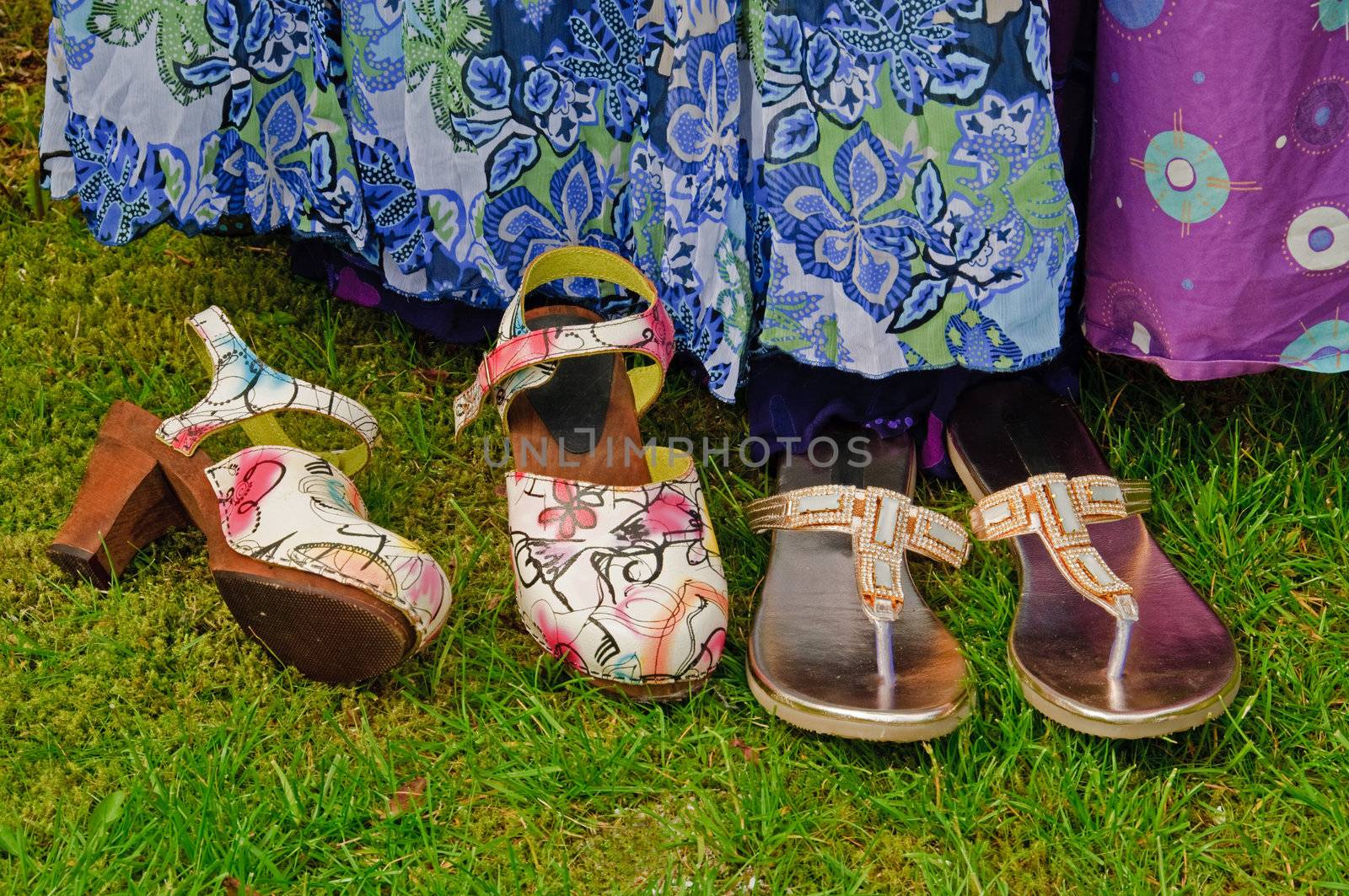 Summer dresses hanging in the garden with two pairs of shoes in front