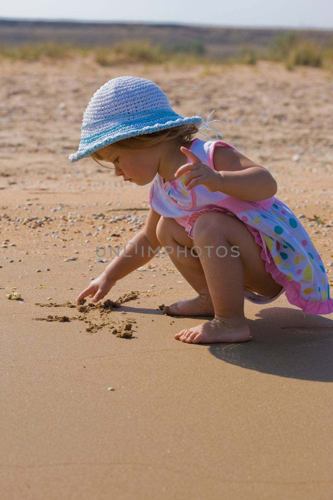 people series: little girl draw on the sand