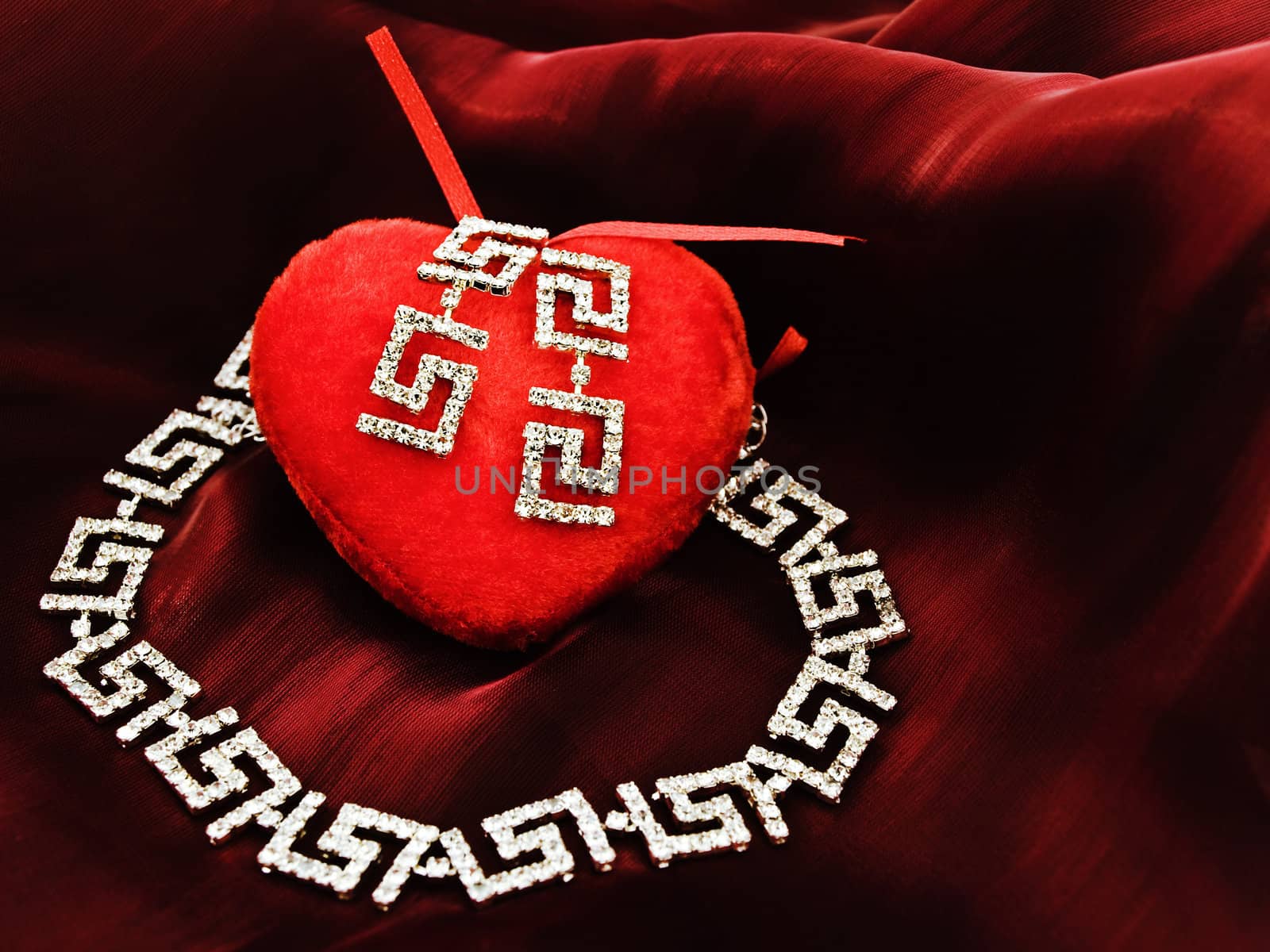 single red plush heart with jewelry set over silk 