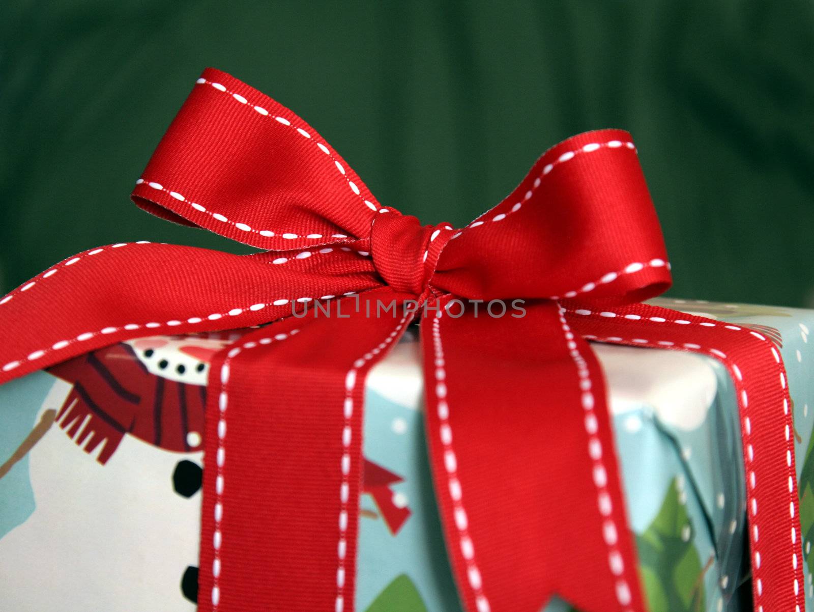 A large Christmas present wrapped with a red ribbon.
