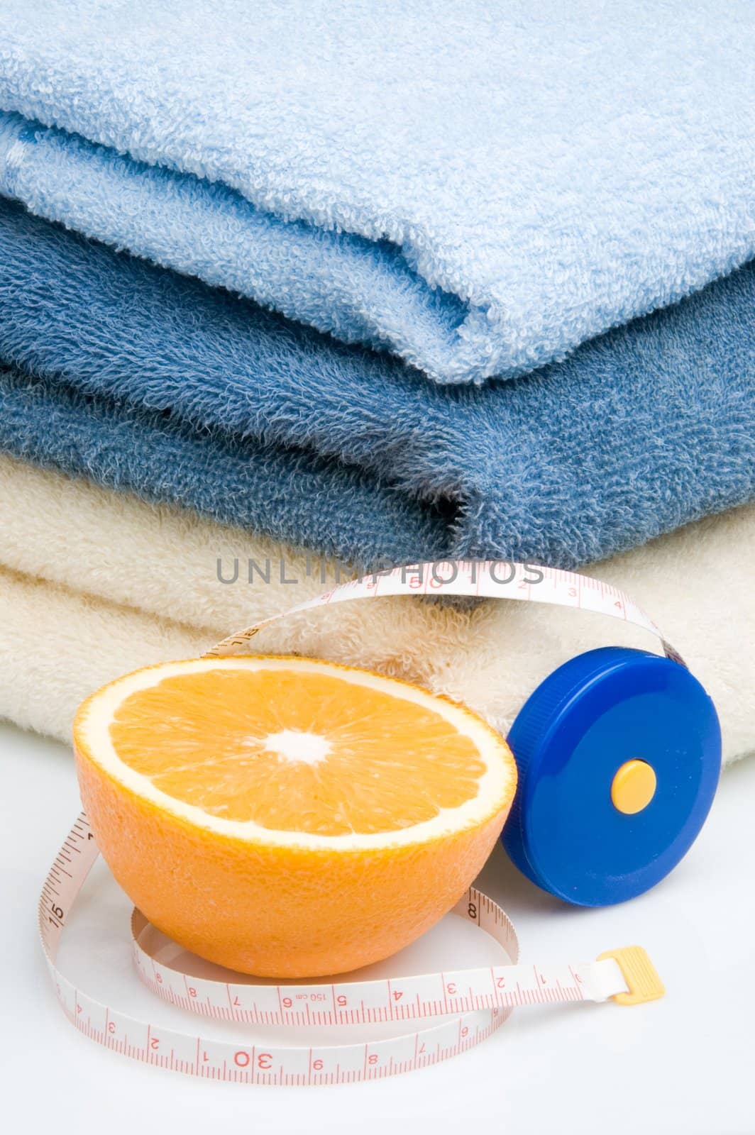 Pile of towels, tape measure and half of orange by Ravenestling