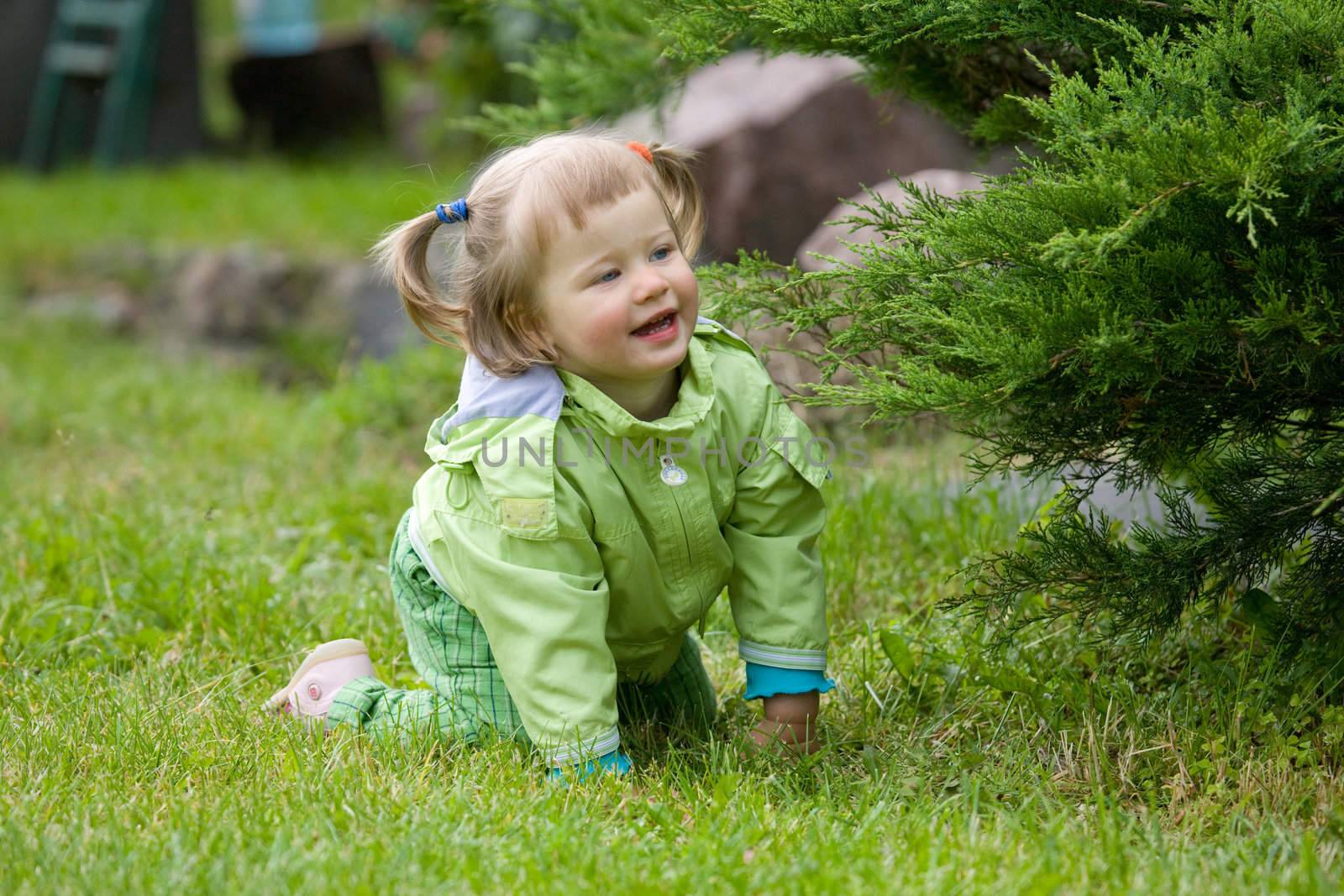 Little girl play on the grass in garden