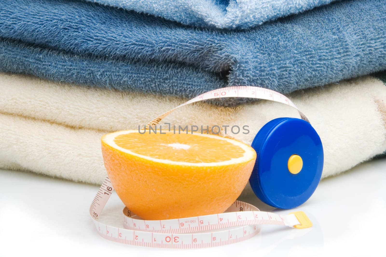 Pile of towels, tape measure and half of orange