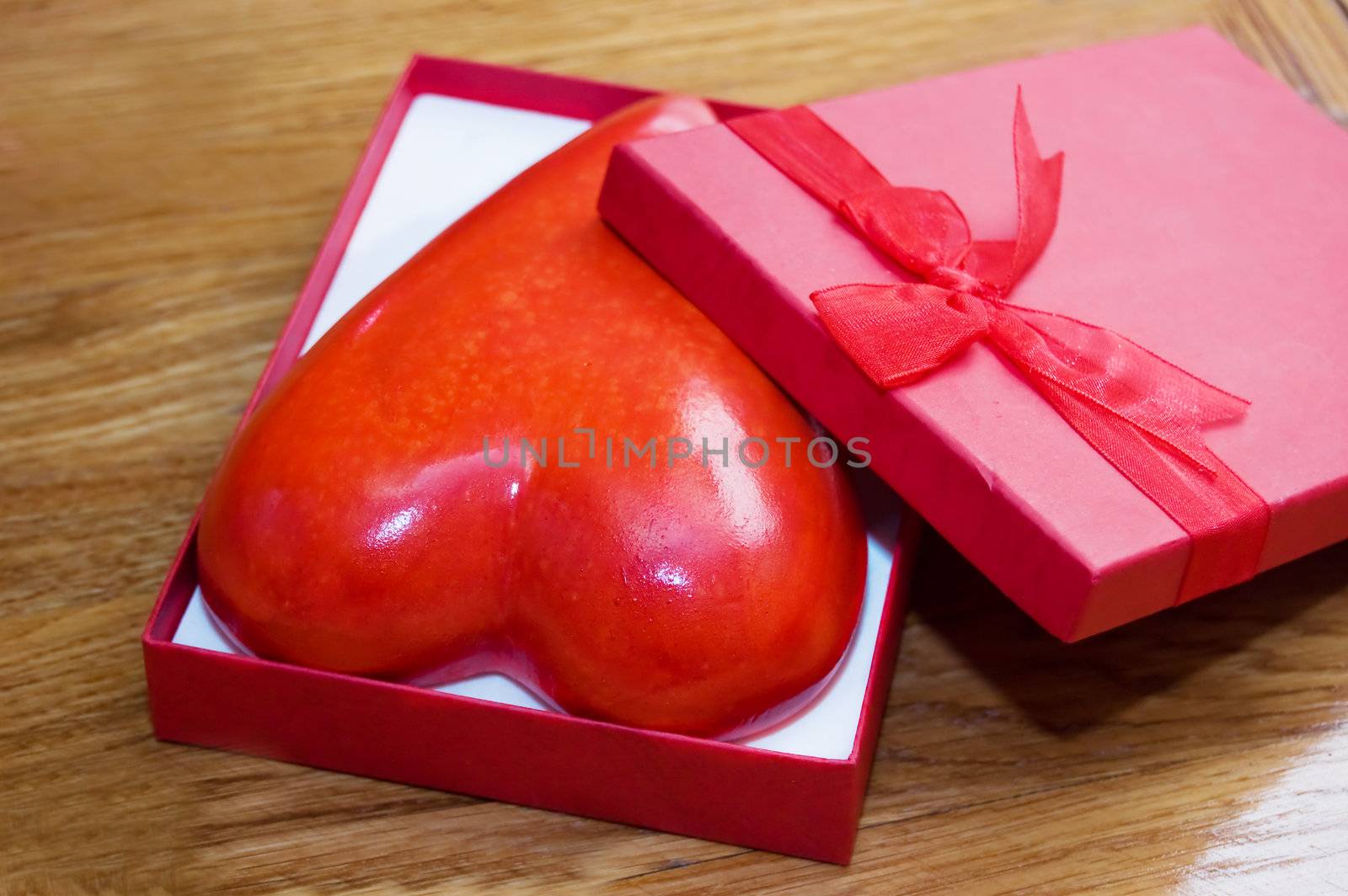 Heart in gift box over wooden background