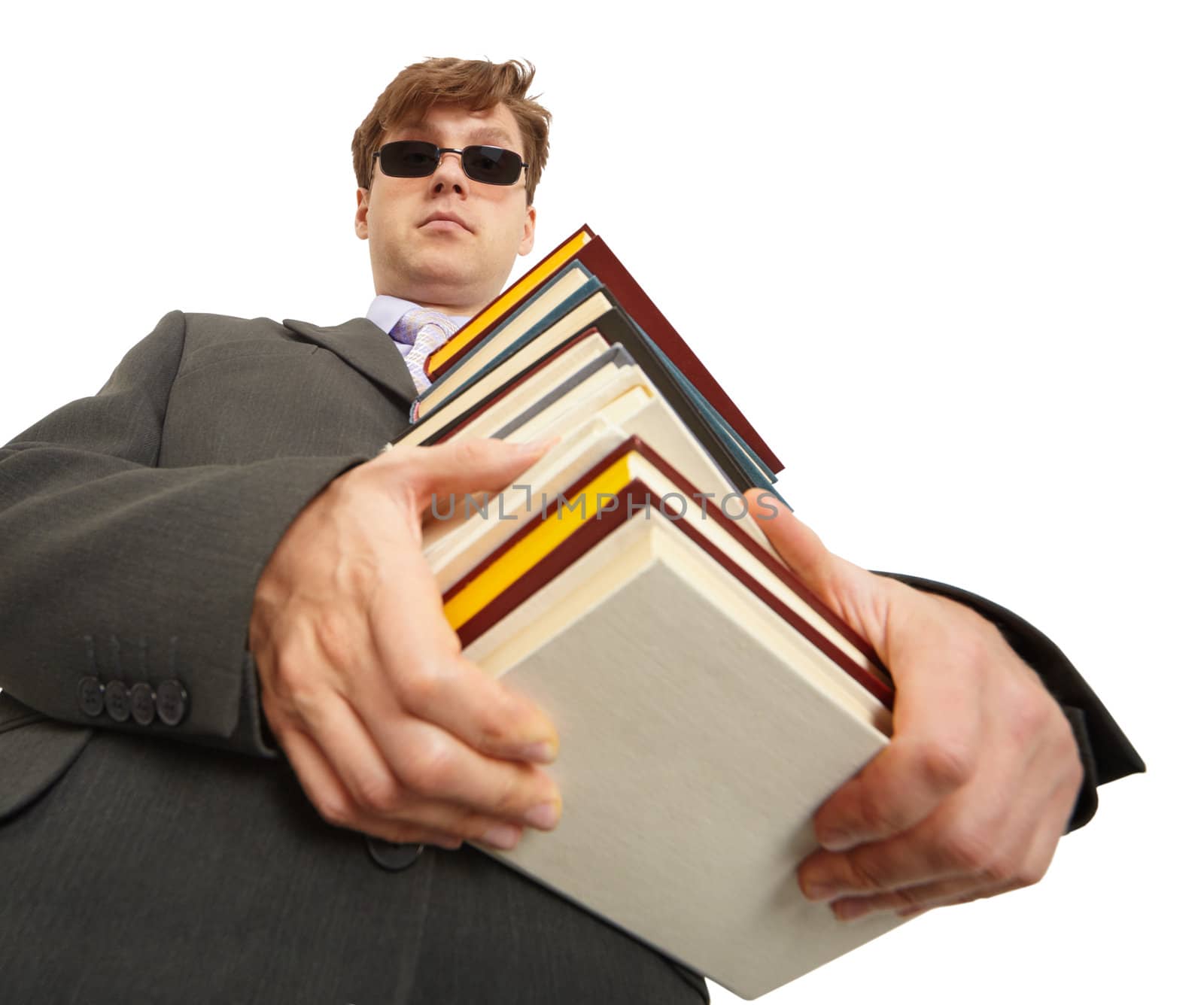 A man in dark glasses holding a lot of books