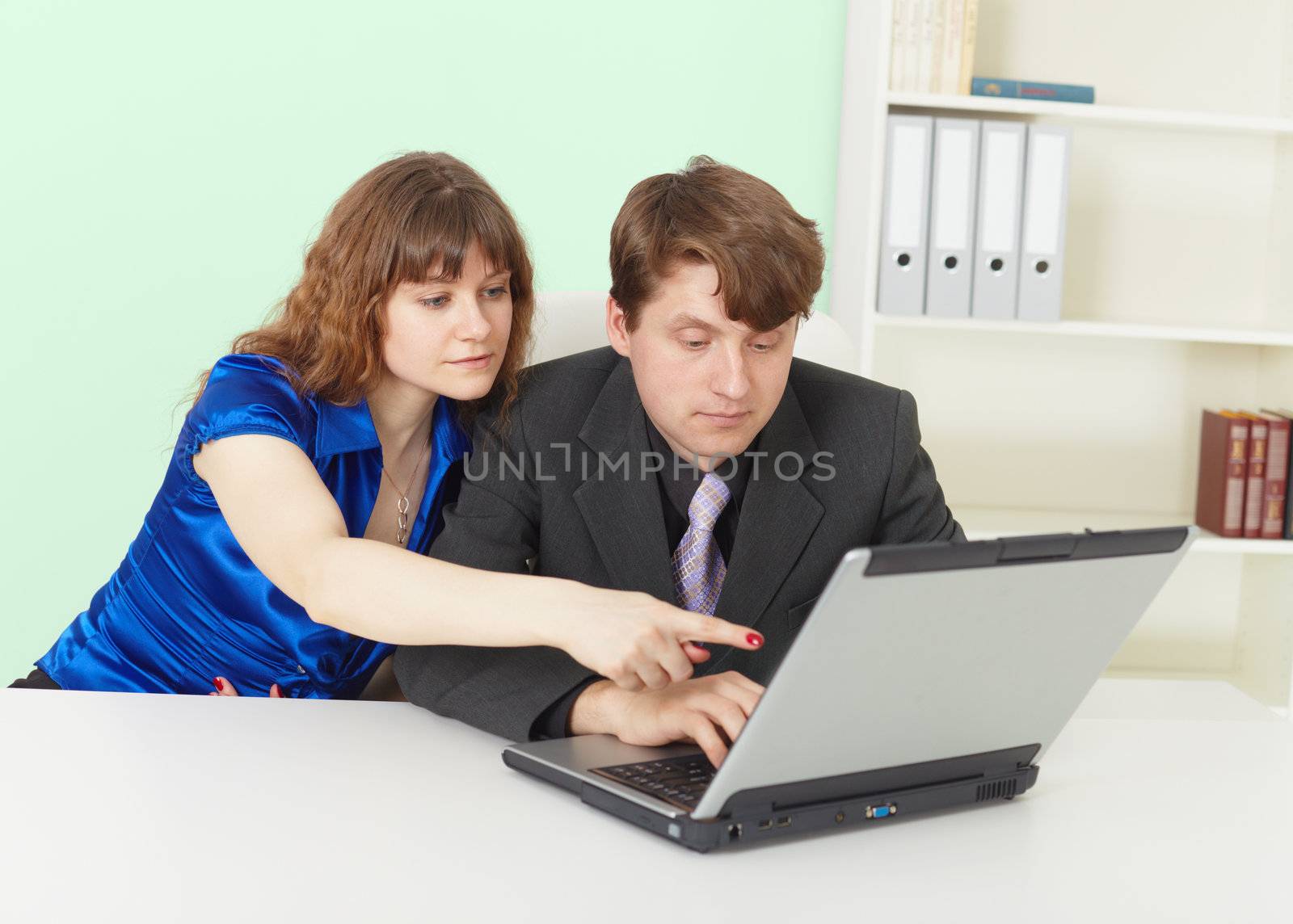 Young people - a man and woman working in an office with computer