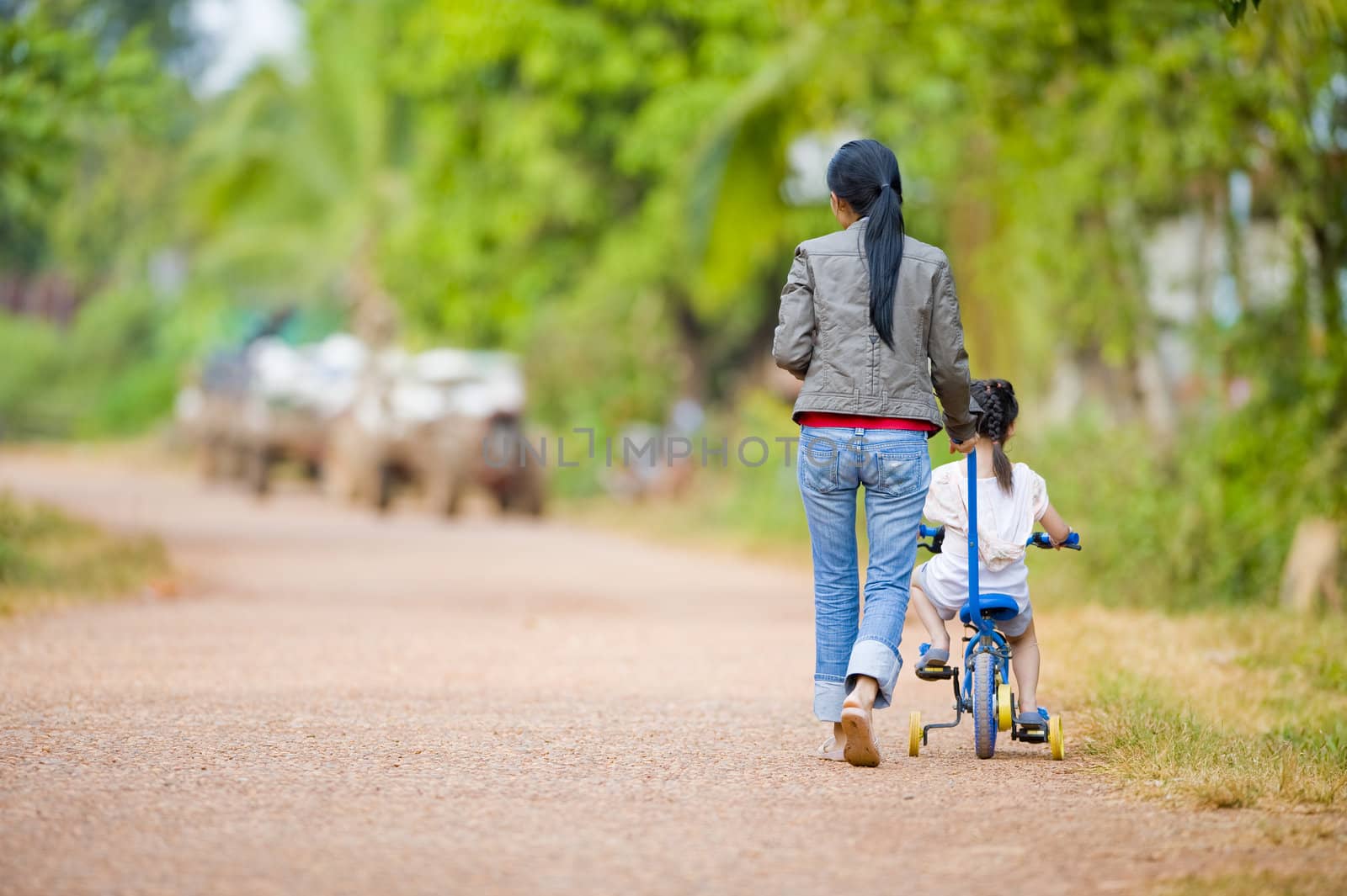 mother guiding her daughter on a bike