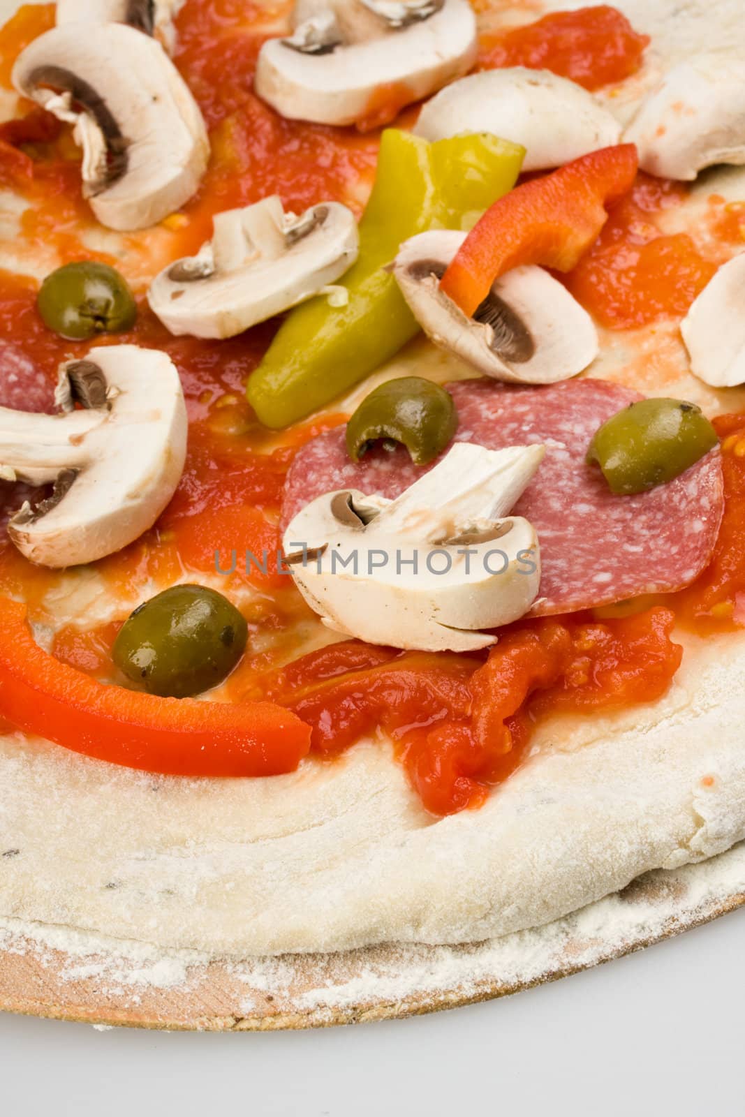 unbaked pizza prepared to bake on a wooden board by bernjuer