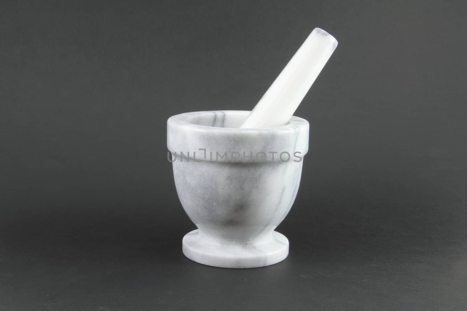 A pharmacist mortar and pestle on a grey background.