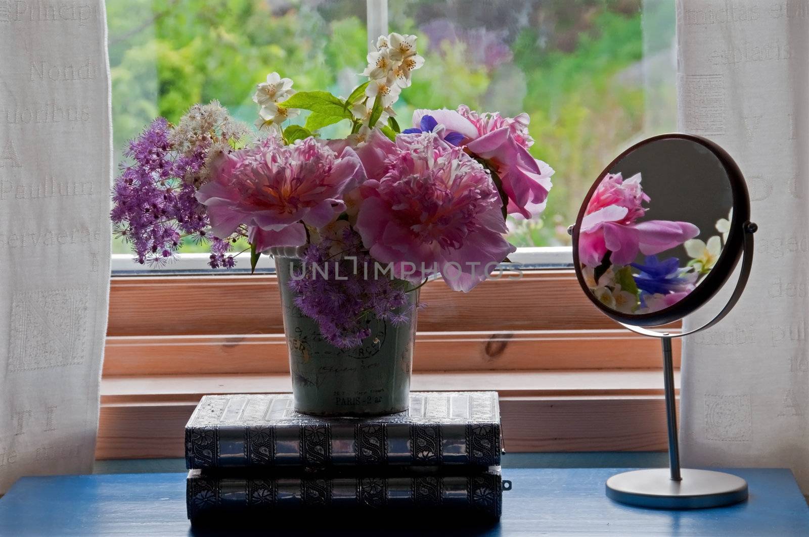 A bouquet of flowers in a bedroom window