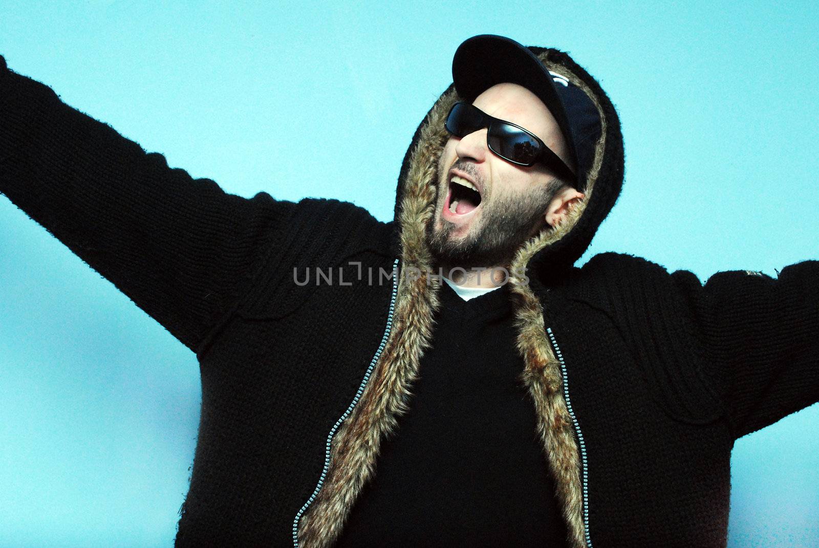Angry man screaming with hip hop apearance on blue background 