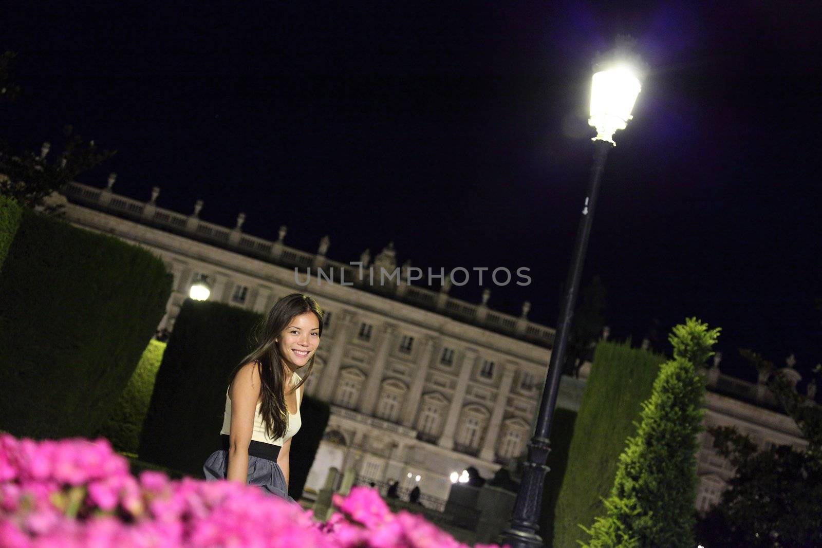 Madrid woman tourist at night in front of the Royal Palace, Spain.