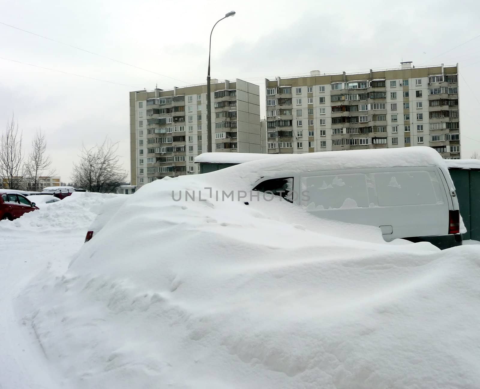 White car with a pile of snow on the top
