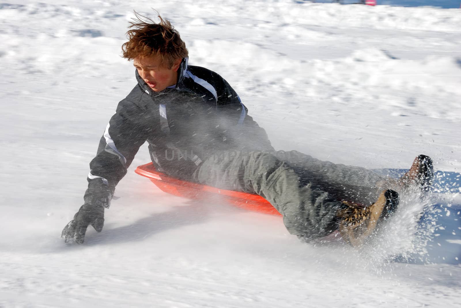 Boy Braking While Sledding Down the Hill by goldenangel