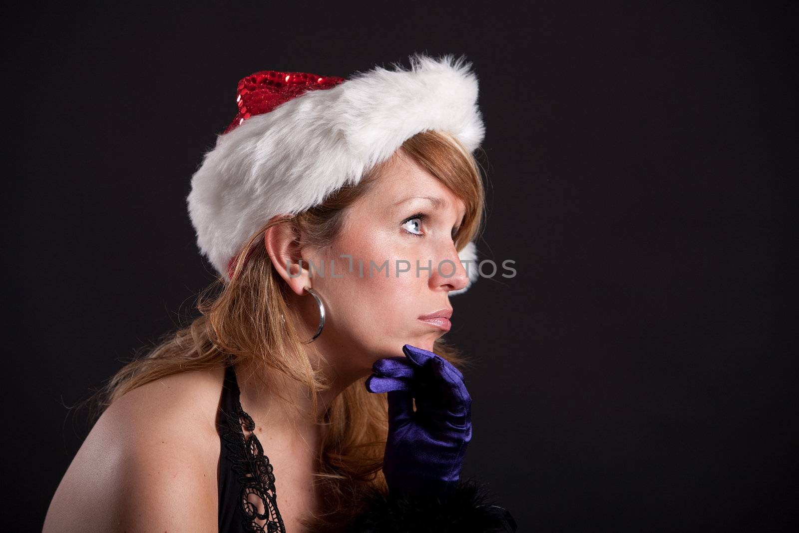 Pretty blond girl wearing a christmas hat being clearly bored