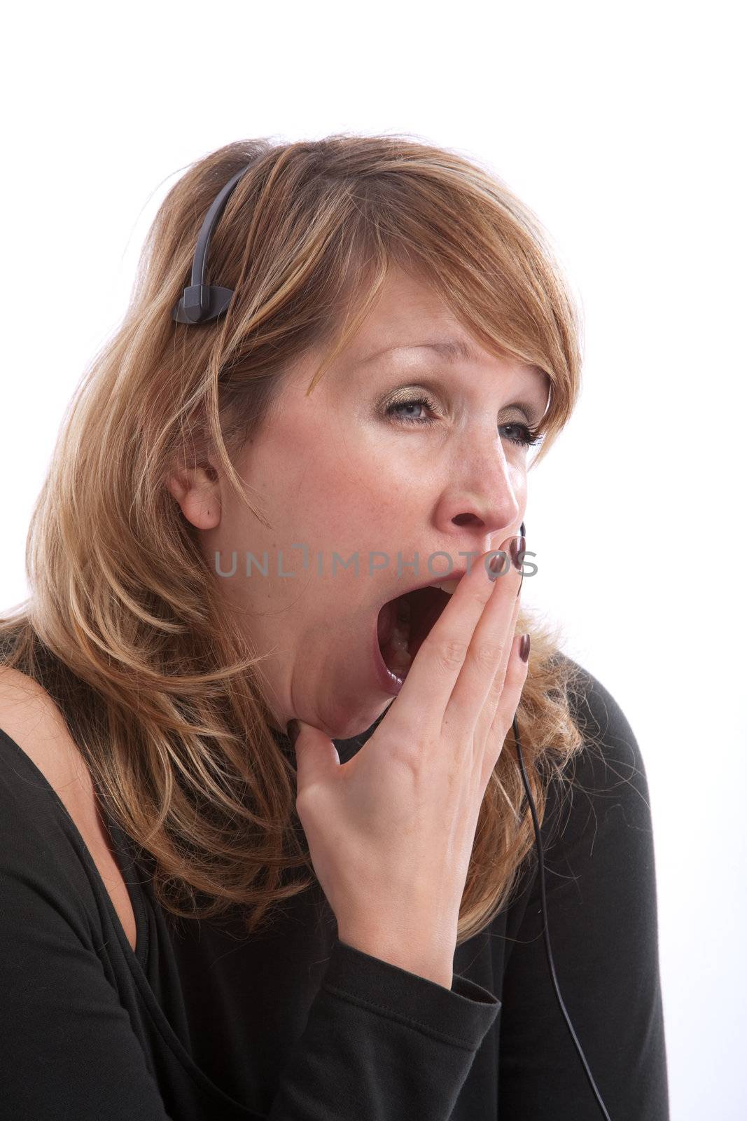 Female receptionist with headset yawning very wide