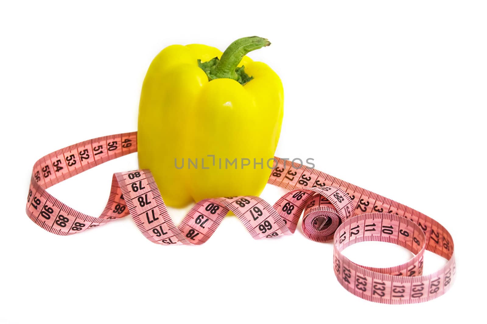 Yellowish pepper with a measuring tape over white