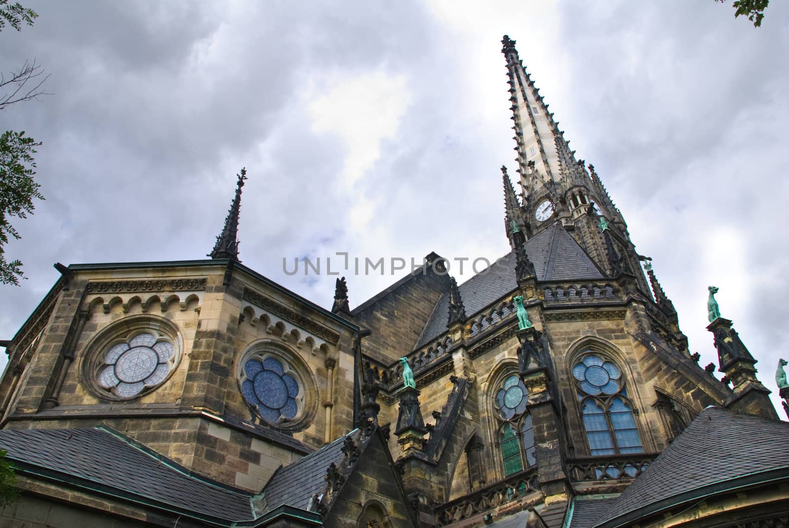 Dark medieval church in city centre of Leipzig against clouds