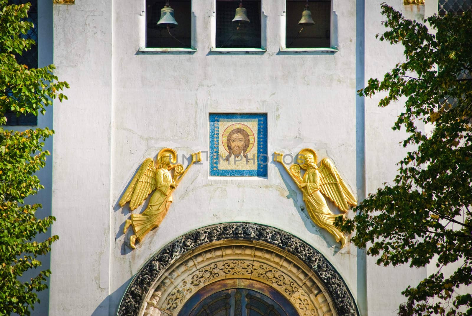 Gold angels on a facade of a white temple at a face of god