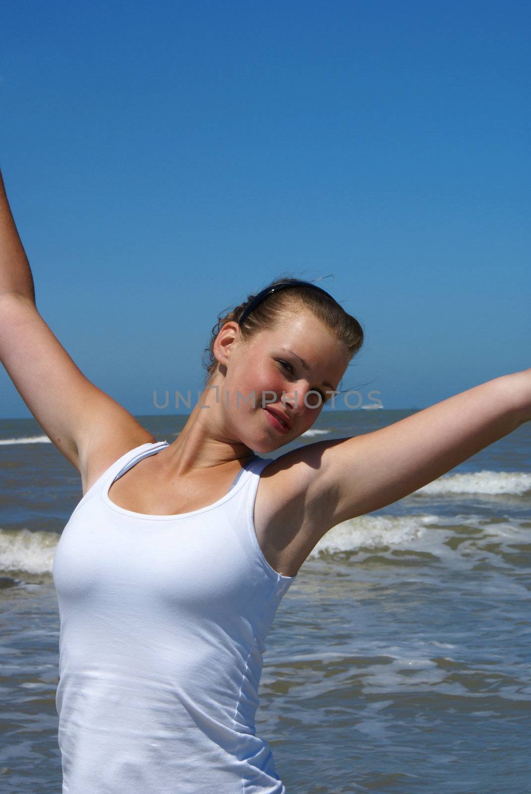 Blond girl in front of the ocean.