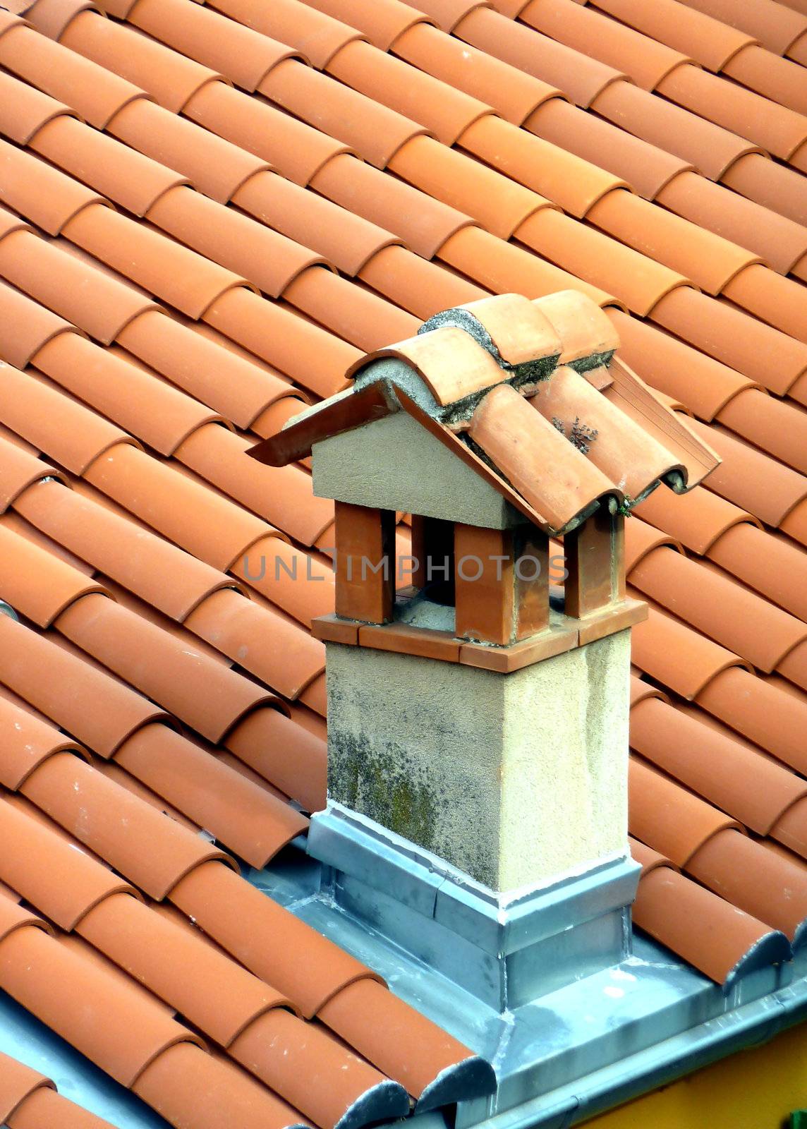 Chimney on a roof made of red tiles