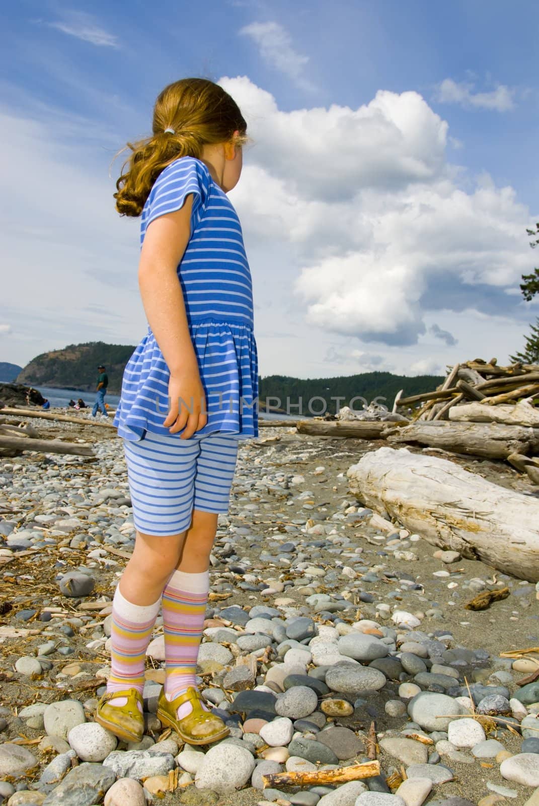 girl in blue on rocky beach by rongreer