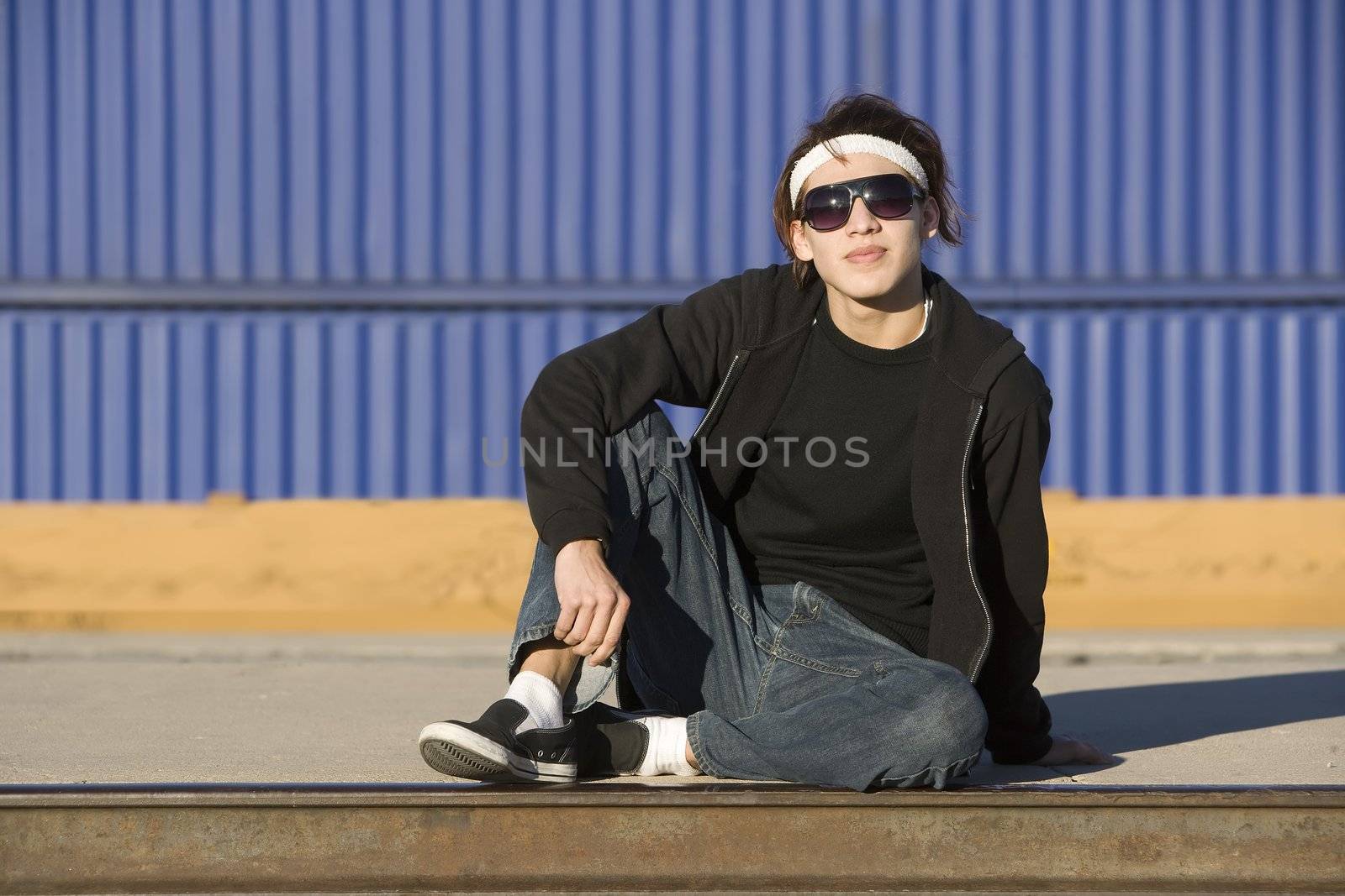 Teenage boy wearing glasses in front of train