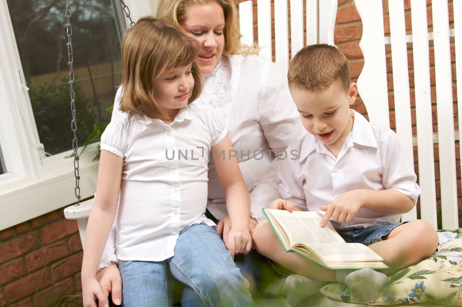 Young Boy Reads to His Mother and Sister