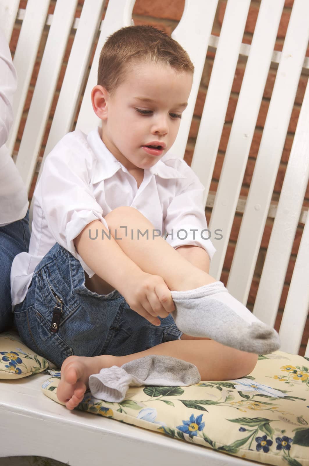 Adorable Young Boy Getting Dressed Putting His Socks On