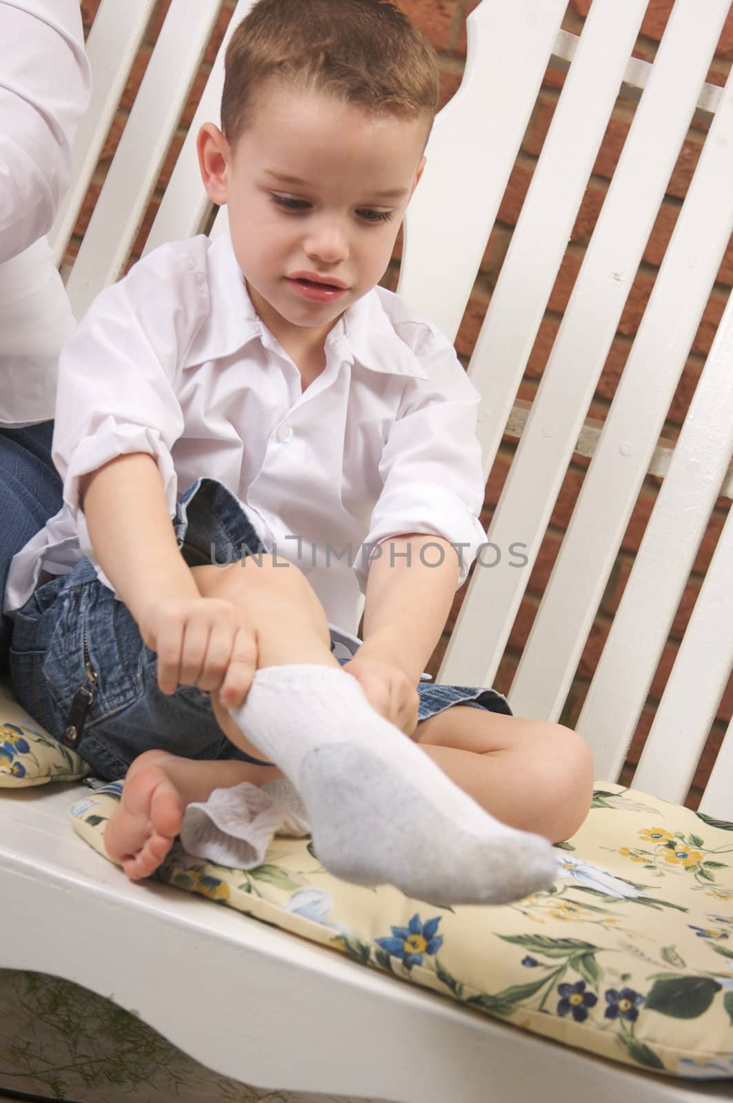 Adorable Young Boy Getting Dressed Putting His Socks On