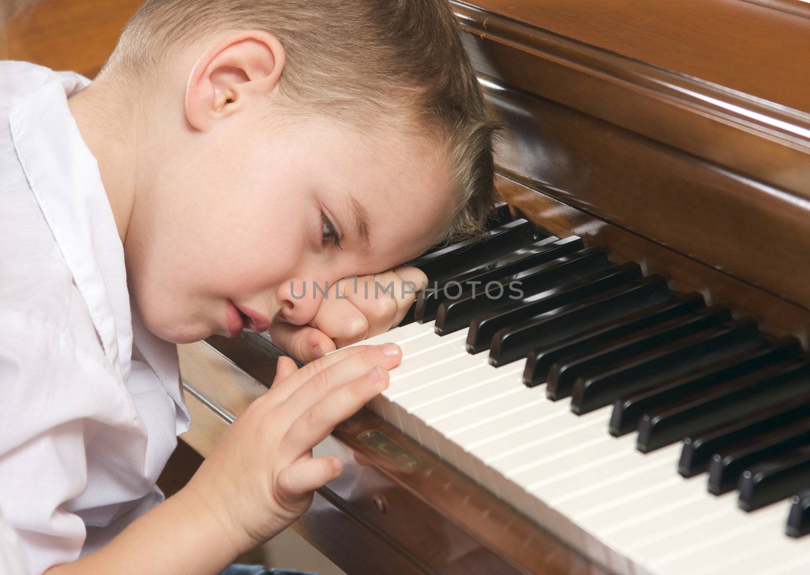 Young Boy with Head on Hand Playing the Piano