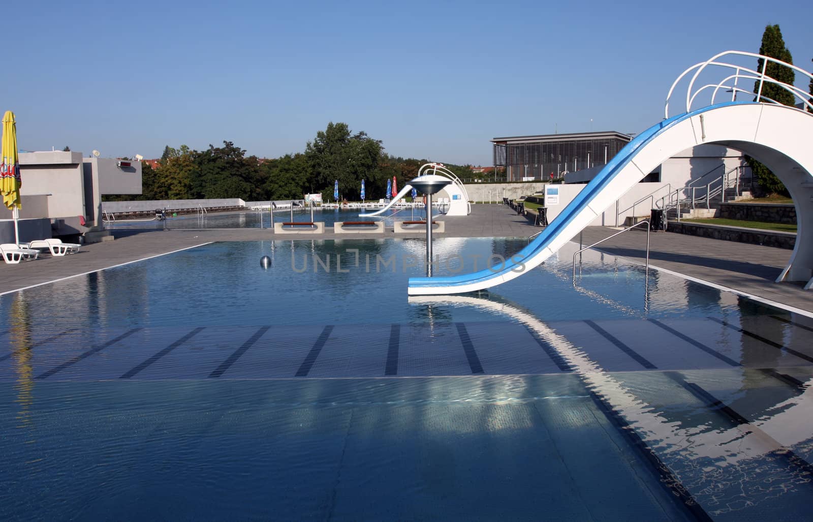 Dispeopled bath pool with white slide