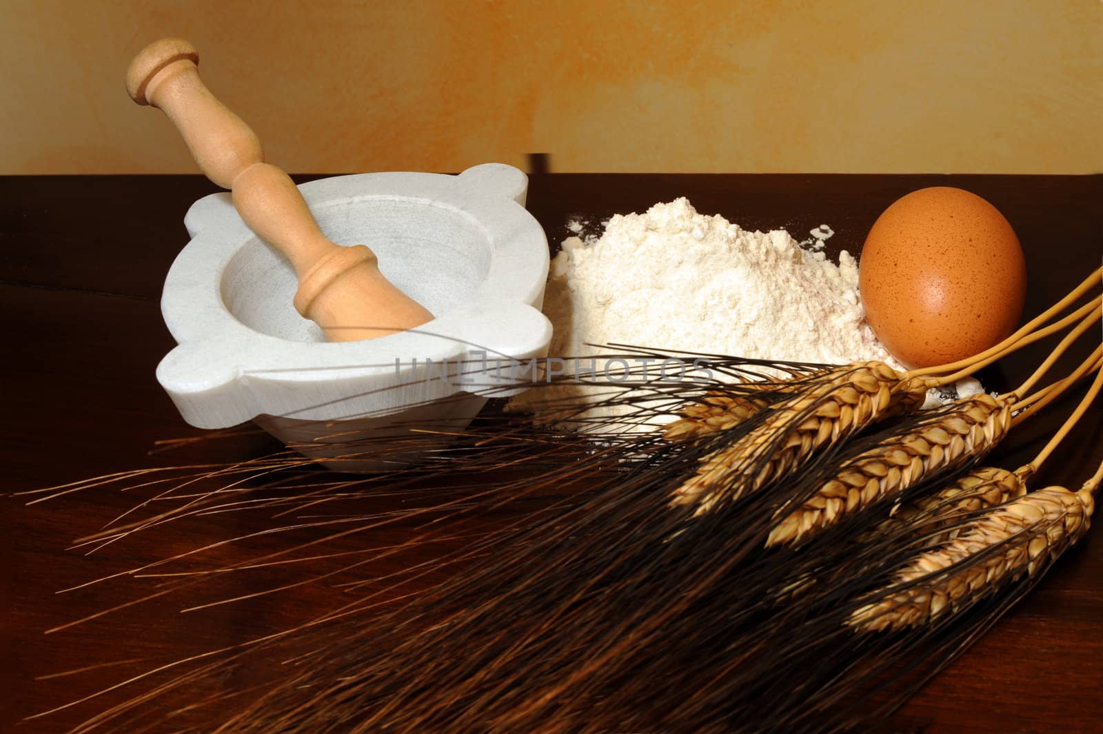 Flour, corn stalks, egg and mortar on wood table