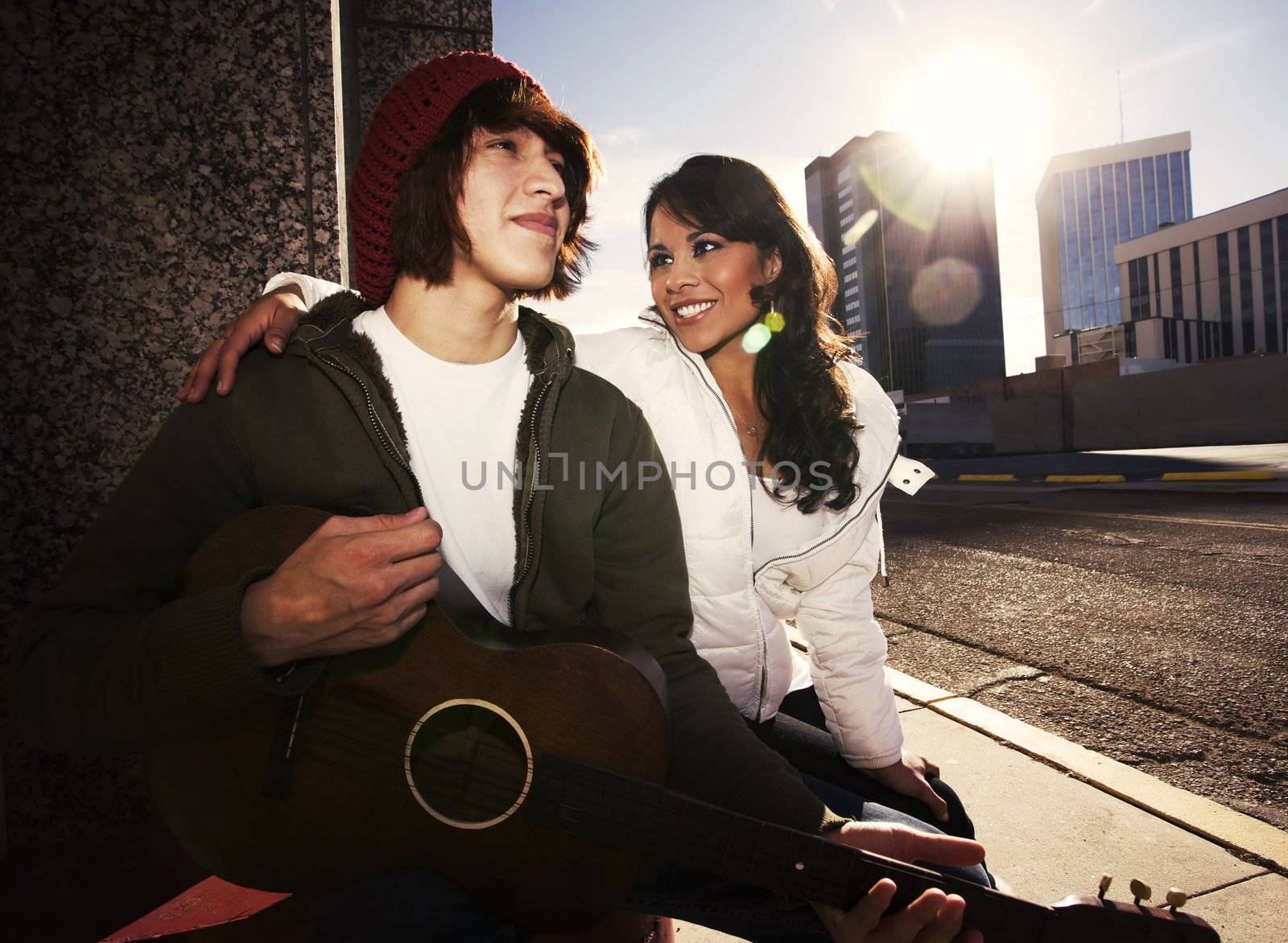 Hispanic musician and Latina Girlfriend downtown at sundown