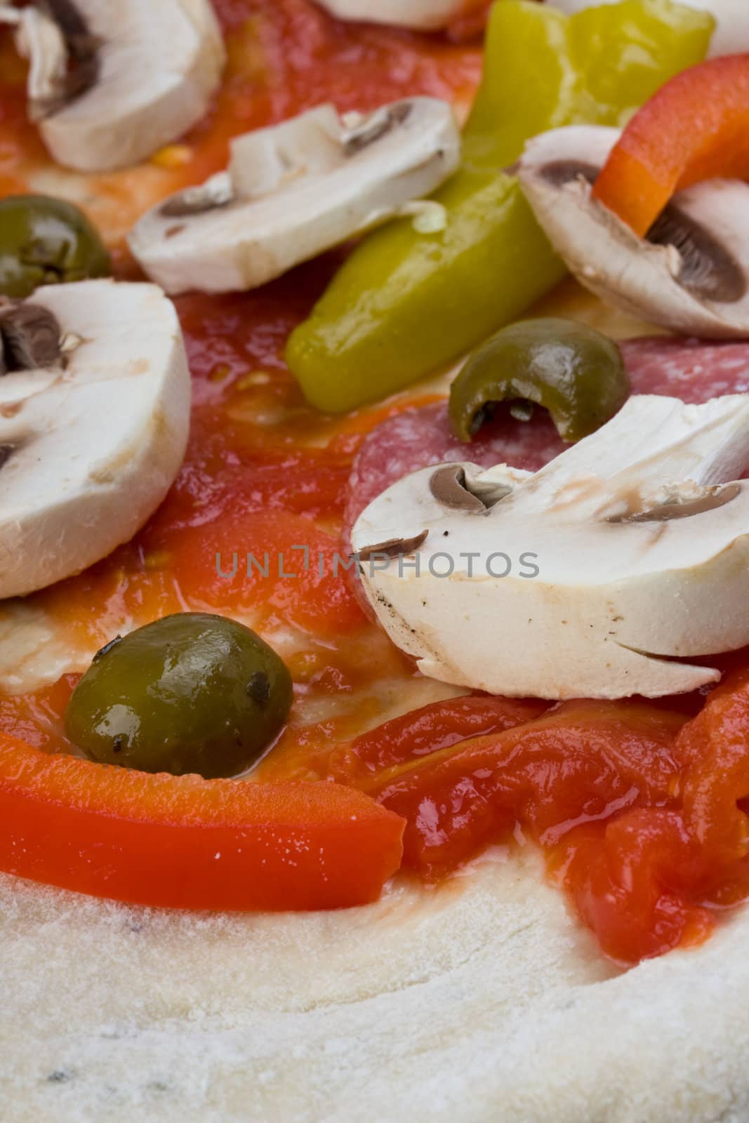 unbaked pizza prepared to bake on a wooden board by bernjuer