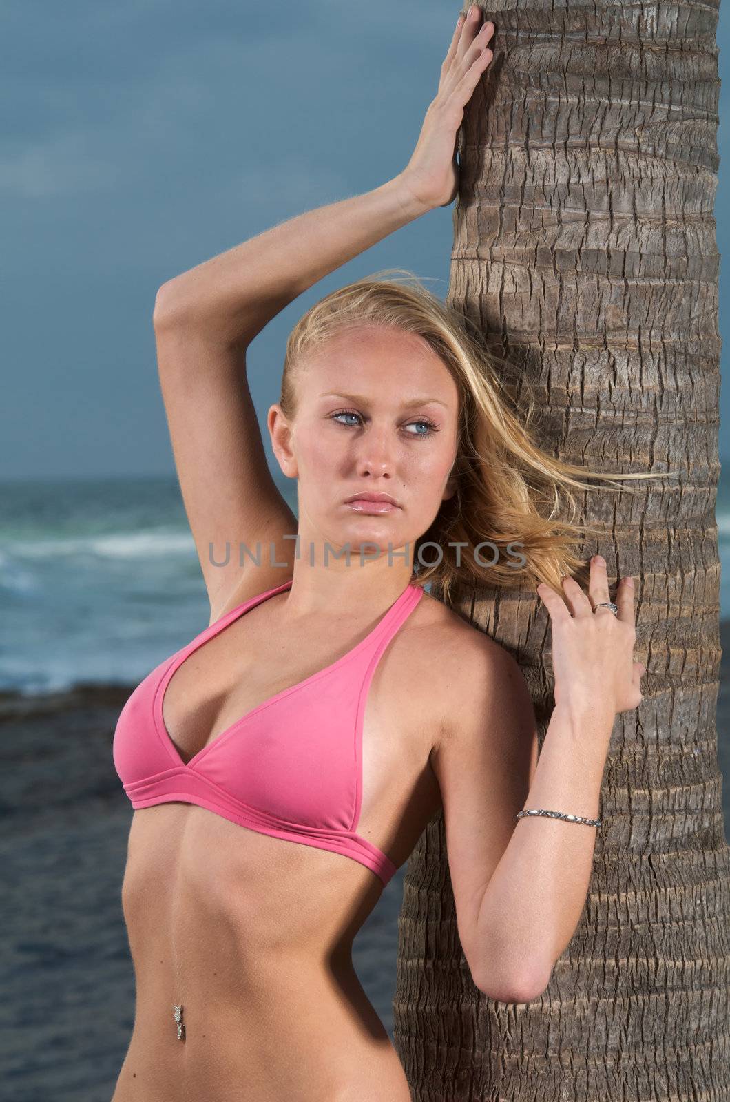 Young Cuacasian Woman in bikini posing in the beach.
