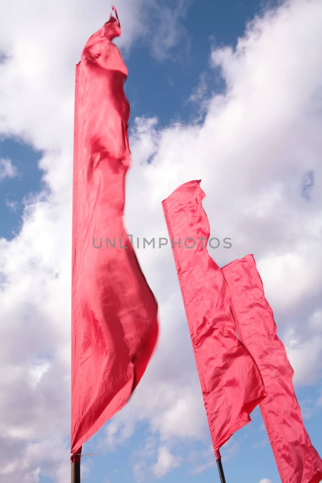three red banners on winds on background blue sky with white clouds