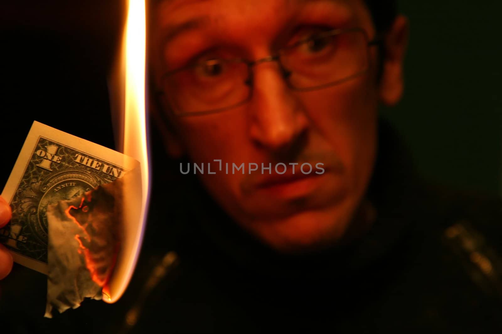 Dollar in Fire on Background of the Alarmed Person