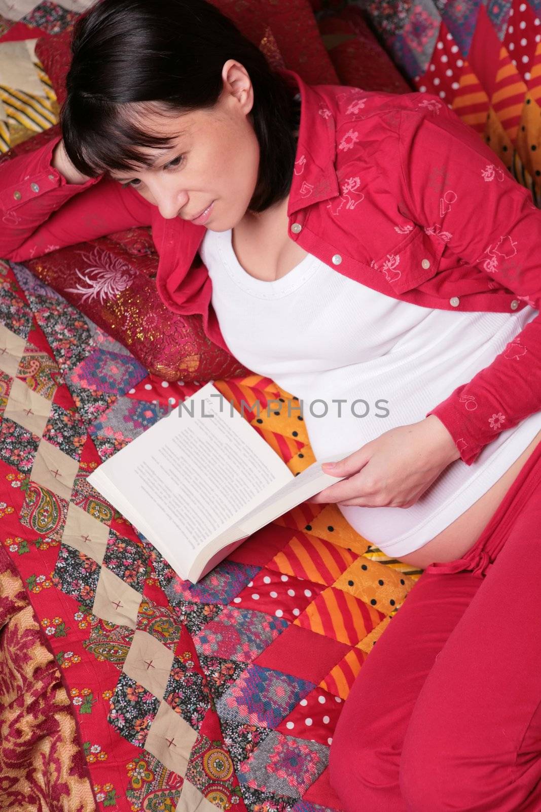 expectant mother in red cloth dreams of future with book in hand