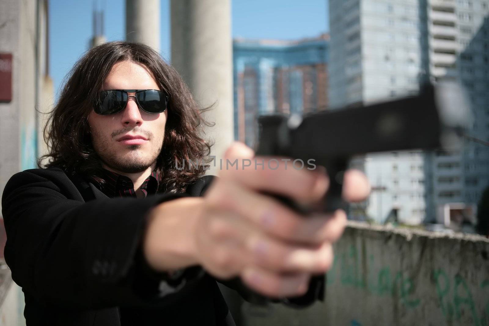 young man with gun in image of the killer in style of the italian film about mafia