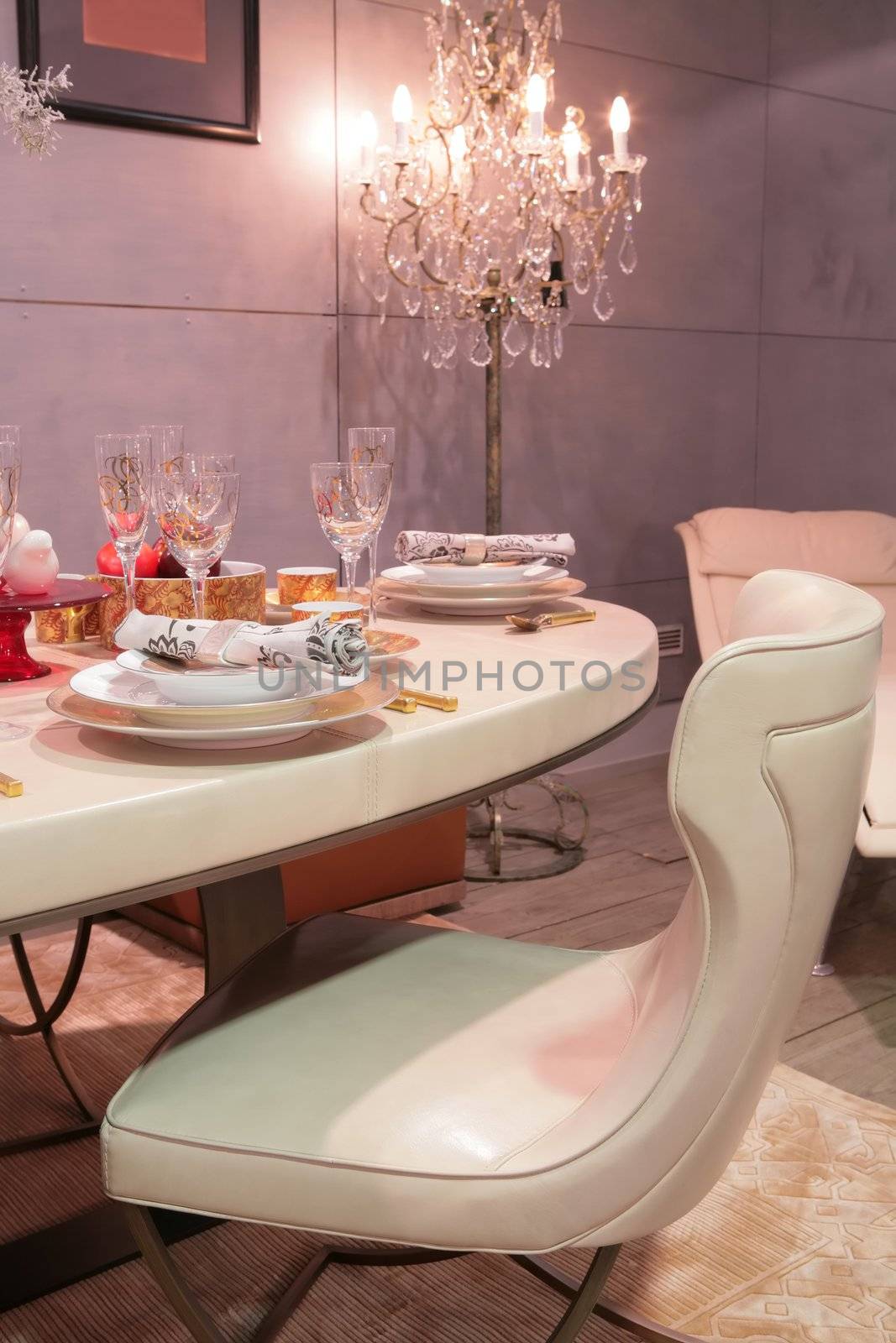 beige leather easy chair in splendid dinning-room beside table with goblet and candelabrum 