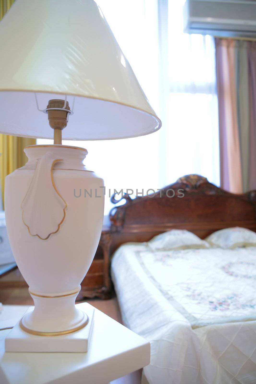 fragment of the bedrooms with lamp in antique style