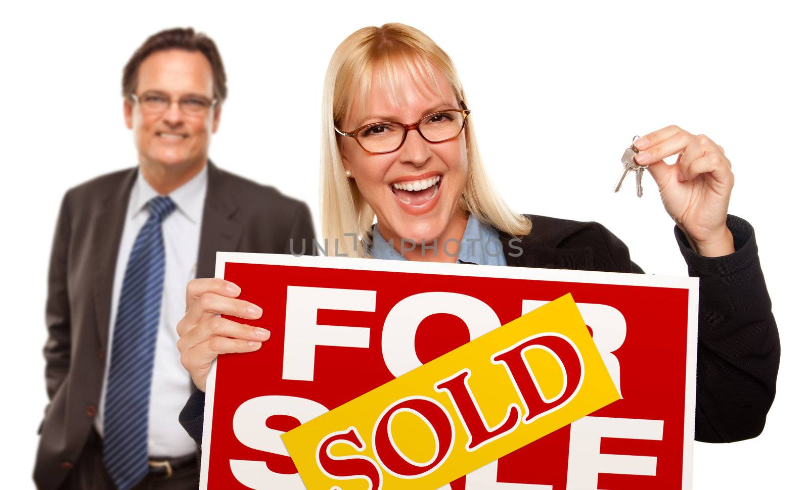 Man Behind with Attractive Blonde in Front Holding Keys and Sold For Sale Sign Isolated on a White Background.