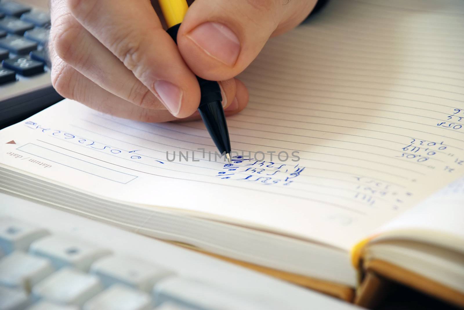 man hand writing in notebook numbers closeup